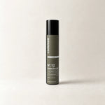 Commen Nº.12 Matte Zinc Gel, a slim 50 ml airless pump bottle with an olive label, standing on light paper.