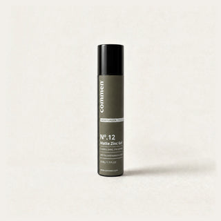 Commen Nº.12 Matte Zinc Gel, a slim 50 ml airless pump bottle with an olive label, standing on light paper.