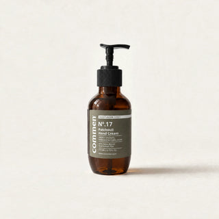 Commen Nº.17 Patchouli Hand Cream, a 270 ml amber pump bottle with an olive label, standing on light paper.