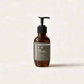 Commen Nº.18 Citrus Hand Cream, a 270 ml amber pump bottle with an olive label, standing on light paper.
