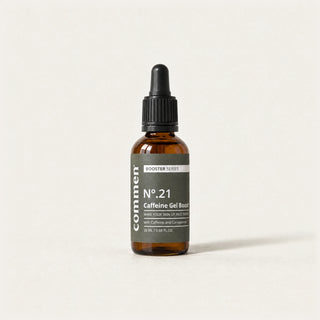 Commen Nº.21 Caffeine Gel Boost, an amber dropper bottle with a dark label, standing on light paper.