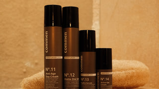 Four Commen Nº.11-14 Moisturiser Series products — Anti-Age Day Cream, Matte Zinc Gel, Hydra Serum and Active Eye Cream — arranged together on a marble bathroom shelf.