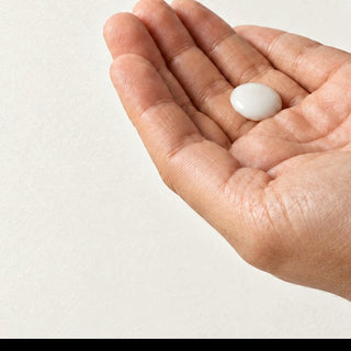 A small dot of Commen Nº.16 Citrus Body Serum is rubbed between the palms: a light, milky serum that sinks in.