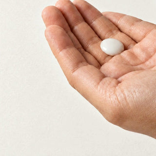 A small dot of Commen Nº.16 Citrus Body Serum is rubbed between the palms: a light, milky serum that sinks in.
