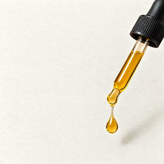 A golden drop of Commen Nº.32 Smooth Beard Oil falls from the glass pipette.